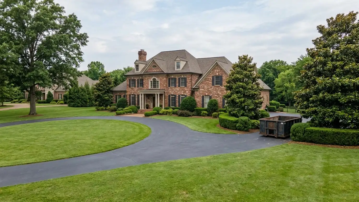 A Brentwood, Tennessee home with a dark green roll-off dumpster in the driveway and renovation debris beside it